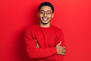 Young african american man wearing casual clothes and glasses happy face smiling with crossed arms looking at the camera. positive person.