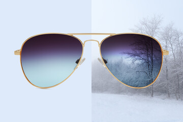 aviator sunglasses isolated on blue and winter background with snow covered trees, concept of...