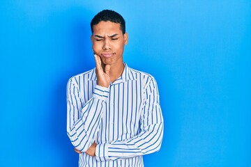 Young african american guy wearing casual clothes touching mouth with hand with painful expression because of toothache or dental illness on teeth. dentist