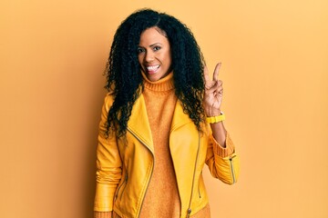 Middle age african american woman wearing wool winter sweater and leather jacket smiling with happy...