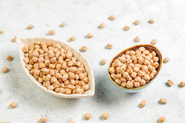 Uncooked dried chickpeas in a different glass jars and bowls.