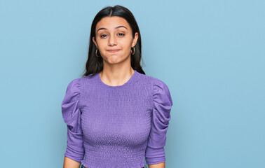 Young hispanic girl wearing casual clothes puffing cheeks with funny face. mouth inflated with air,...