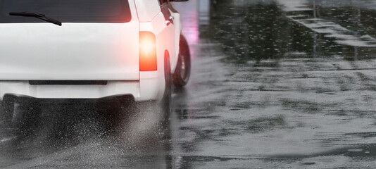Heavy rain and puddles on the road cause skidding or sliding of a cars tires across a wet surface