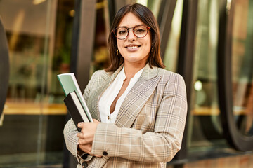 Young hispanic businesswoman smiling happy standing at the city.