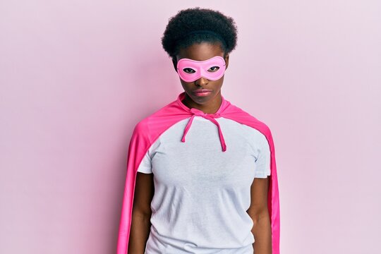 Young african american girl wearing superhero mask and cape costume depressed and worry for distress, crying angry and afraid. sad expression.