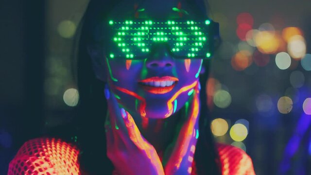 Neon  asian woman dancing. Fashion model woman in neon light, portrait of beautiful model with fluorescent make-up, Art and future design of female disco dancer posing in UV, colorful make up.