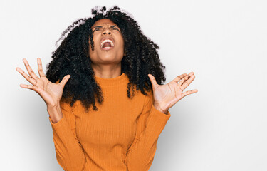 Young african american girl wearing casual clothes crazy and mad shouting and yelling with aggressive expression and arms raised. frustration concept.