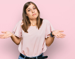 Beautiful caucasian woman wearing casual clothes clueless and confused expression with arms and...