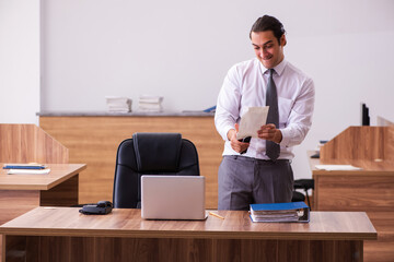 Young male employee stapling paper in the office