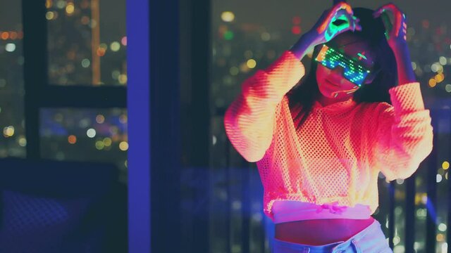 Neon  asian woman dancing. Fashion model woman in neon light, portrait of beautiful model with fluorescent make-up, Art and future design of female disco dancer posing in UV, colorful make up.