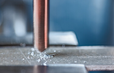 Drilling process with shavings close-up at the workplace in workshop