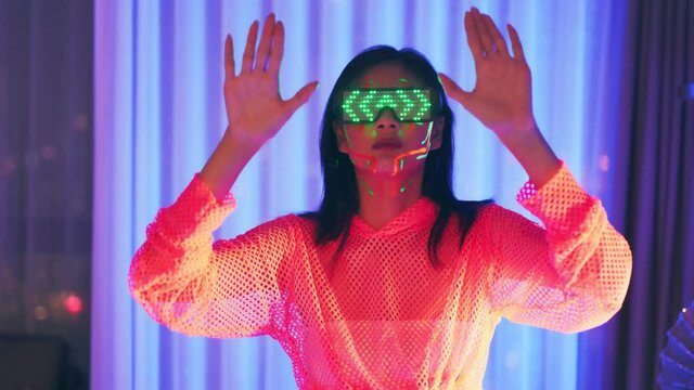Neon  asian woman dancing. Fashion model woman in neon light, portrait of beautiful model with fluorescent make-up, Art and future design of female disco dancer posing in UV, colorful make up.