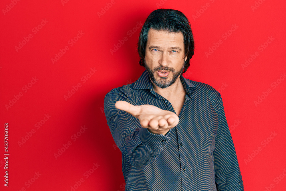 Poster middle age caucasian man wearing casual clothes looking at the camera blowing a kiss with hand on ai