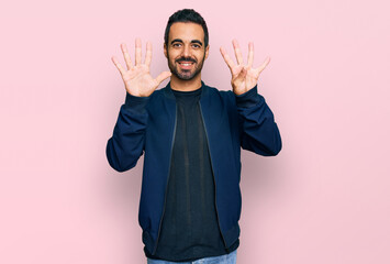 Young hispanic man wearing casual clothes showing and pointing up with fingers number nine while...