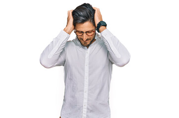 Young hispanic man wearing business shirt and glasses suffering from headache desperate and stressed because pain and migraine. hands on head.