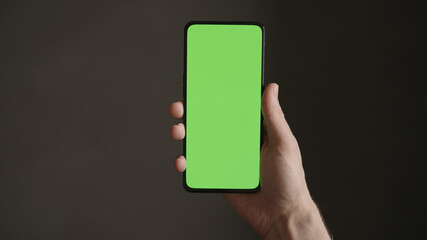 POV top view shot of man hold phone with green screen indoor