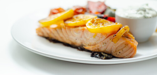 Grilled salmon fillet served with roasted vegetables with cucumber and dill sauce