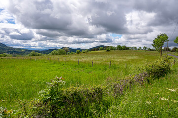 Naklejka premium Paysage d'Auvergne en Haute-Loire en France au printemps avec un ciel menaçant