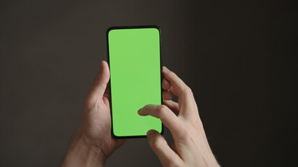 POV top view shot of man using phone with green screen indoor