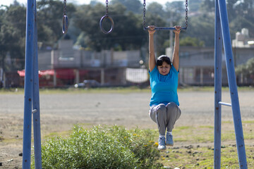 Mexican aged woman training on a playground