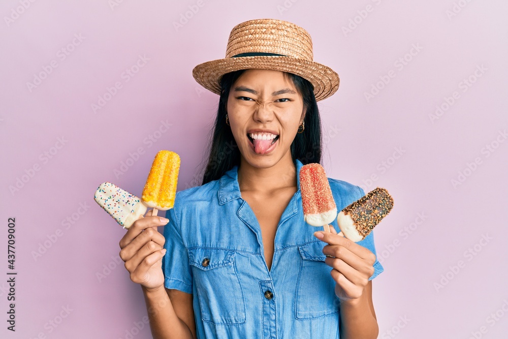 Sticker young chinese woman wearing summer style holding ice cream sticking tongue out happy with funny expr