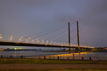 Fototapeta na wymiar Die Rheinbrücke, die Düsseldorf mit Neuss verbindet. Nachts an der düsseldorfer Rheinpromenade