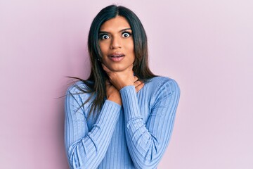 Fototapeta premium Young latin transsexual transgender woman wearing casual clothes shouting and suffocate because painful strangle. health problem. asphyxiate and suicide concept.