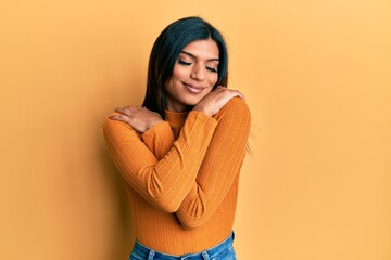 Young latin transsexual transgender woman wearing casual clothes hugging oneself happy and positive, smiling confident. self love and self care