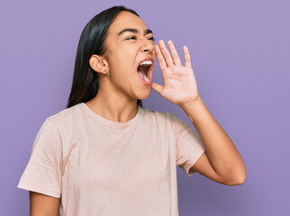 Young asian woman wearing casual clothes shouting and screaming loud to side with hand on mouth. communication concept.