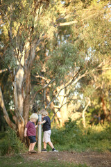 Fototapeta premium Little boys spinning around fence post in the Australian bush
