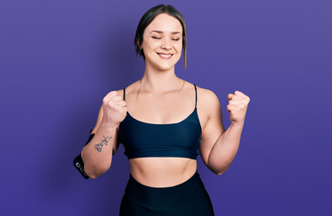 Fototapeta na wymiar Young hispanic woman wearing sportswear excited for success with arms raised and eyes closed celebrating victory smiling. winner concept.