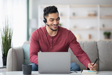 Cheerful arab guy attending online training from home