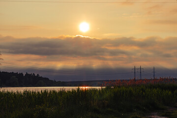 Setting sun over a rain cloud. The sun is in the smoky air