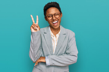 Young african american woman wearing business clothes smiling with happy face winking at the camera...