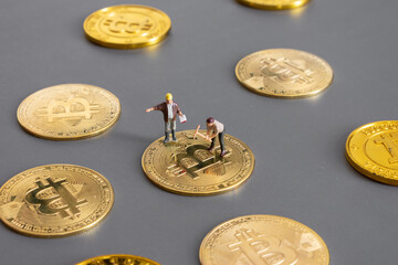 cryptocurrency concept with bitcoin symbol and Miniature human on Golden coins