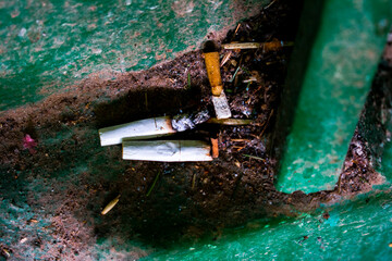 Photos of the remains of cigarettes, that is, cigarette butts in the entrance. Pollution.
