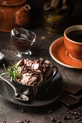 Chocolate coffee ice cream balls in a bowl over dark background