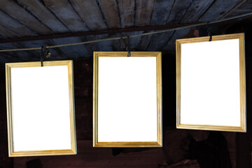 Three old photo frames with white list in a garage. There are it in background in a dark garage