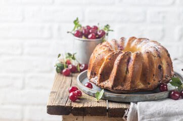 Fresh homemade bundt cake with cherry on wooden table