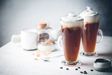 Iced coffee in a tall glasses with cream poured over