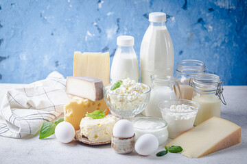 Fototapeta na wymiar Fresh dairy products, milk, cottage cheese, eggs, yogurt, sour cream and butter on blue background
