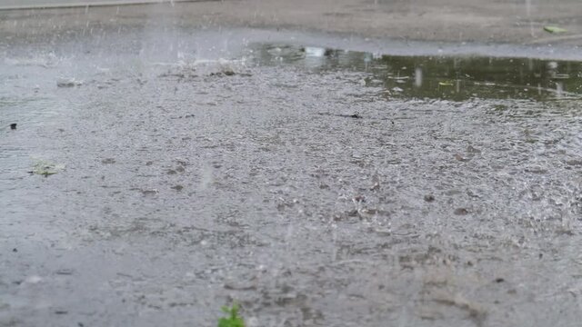 Male foot in a shoe stepping into a puddle running somewhere, slow motion