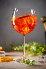 Aperol spritz cocktail in glass with fresh orange on gray background