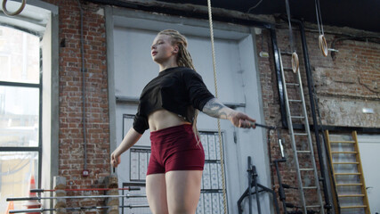 A strong athletic woman is jumping rope