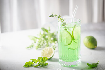 Summer green drink, lemonade with lime, basil and ice in a glass