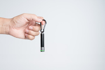 Hand holding small LED flashlight with pointing laser - obrazy, fototapety, plakaty