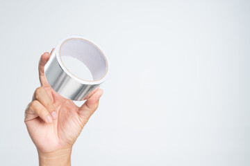 Hand holding adhesive aluminum foil tape for padding