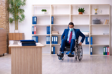 Young disabled employee during pandemic at workplace
