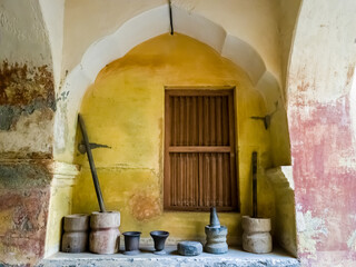 Collection of ancient stone mortar pestles in an arched recess in the old Maratha Palace museum.