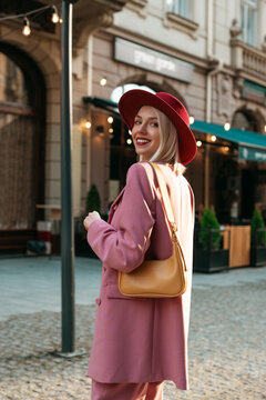 Outdoor Portrait Of Elegant Smiling Woman Wearing Stylish Pink Blazer, Burgundy Hat,  With Yellow Shoulder Bag, Walking In Street Of European City